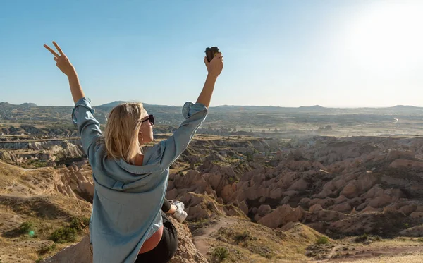 Jonge Vrouw Zit Aan Rand Van Vallei Glimlacht Naar Zon — Stockfoto