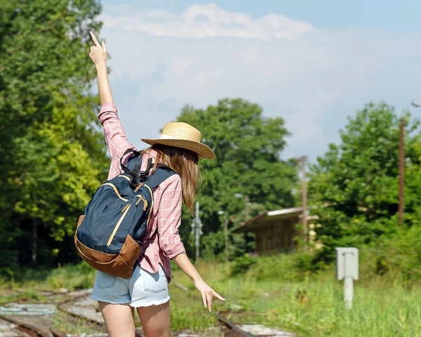 Tren istasyonunda tren beklerken kadın gezgin eğleniyor. Tek başına seyahat kavramı