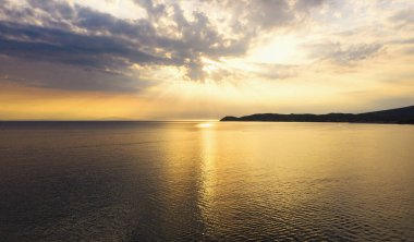 Sahilde altın bir saat Dağların arkasında