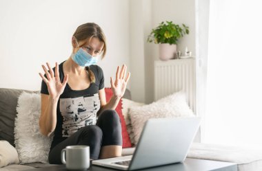 Evde tıbbi maskeli bir kadın ailesiyle görüntülü konuşma yapıyor..