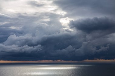 Denizin altında kara bulutlar ve güneş