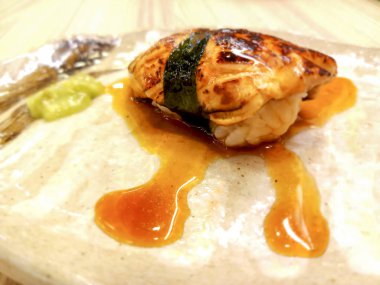 Kaz ciğeri suşi yosun ve özel sos sarılı. Wasabi ile hizmet etmiş. Bu gıda diğer türleri aksine, benzersiz bir tadı vardır.