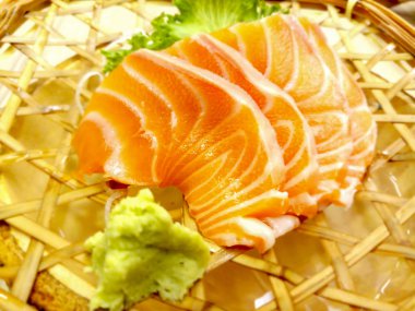 Taze sashimi somon ve wasabi ve cam marul dokuma rattan çanak servis edilir. Somon Sashimi Japonya ve Asya'da çok popüler.