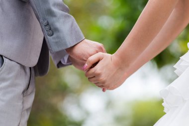 Gelin ve damat, aşk sembolü olarak düğün selemonisinde el ele tutuşuyorlar.