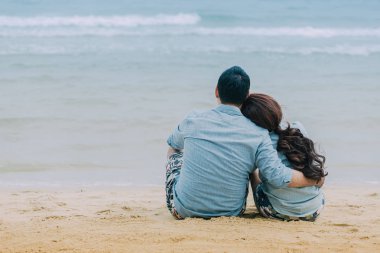 Genç çiftler rahatlatıcı güzel bir plajda.