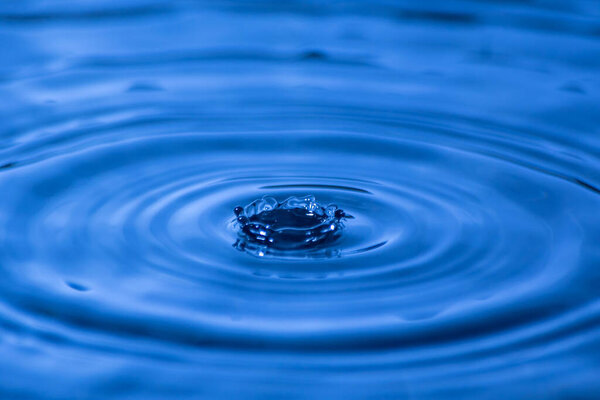 Water drop close up of in a blurred blue background