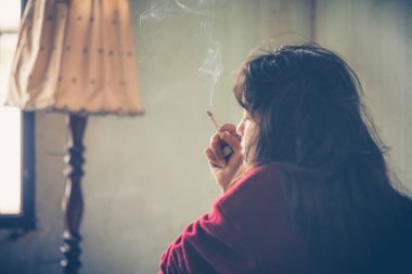 Stresli kadın. Stres altında sigara içen bir kadın sosyal sorunlardan kaynaklanan uyuşturucu ve suçla ilgili bir kavramdır.