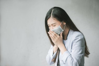 Öksüren ve grip enfeksiyonu olan kadınlar, covid-19, coronavirus, bu yüzden ağzı ve burnunu kapatmak için maske takmak zorundalar..