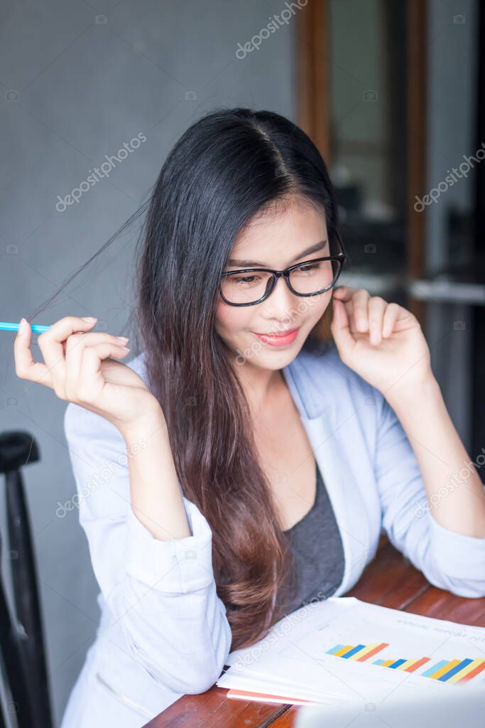 Business women wear glasses Beautiful asians Have fun in the office inside the house during work at home.