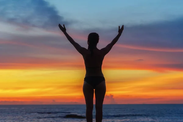 strong confidence woman open arms under the sunrise at seaside