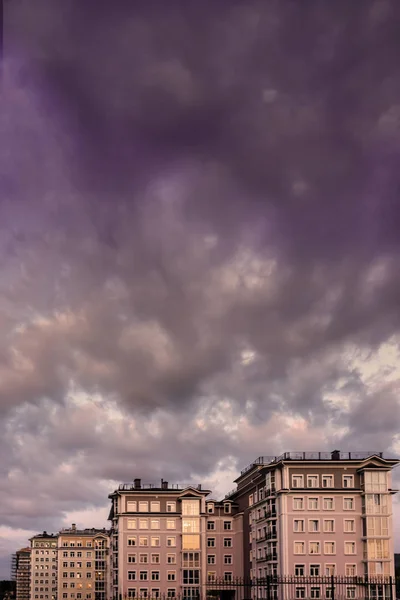 buildings at sunset in the evening under a dramatic dark sky. Krasnoyarsk, Russia. vertical view