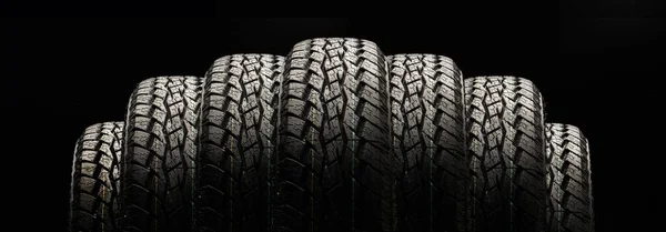 tires on a black background in a row, panoramic photo.