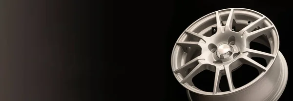 New silver alloy wheel on a black background,panoramic photo for the site header or advertising, copy space.