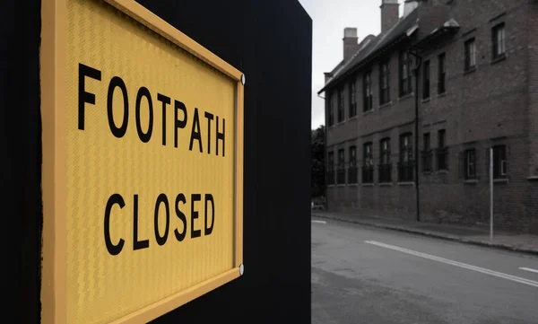 Footpath closed sign on a black fence