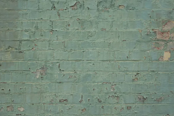 Flaking painted teal brick wall