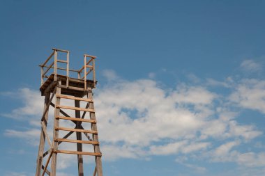 Güneşli bir günde plajda eski ahşap hayat kurtaran kule