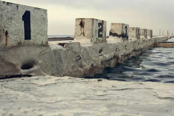 当地海洋浴场的混凝土 编号潜水区 背景为绿色混凝土休息区 — 图库照片