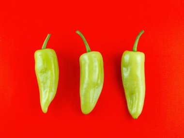 Taze yeşil biber kırmızı arka plan izole