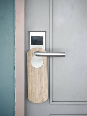 Kapıda tabela olan otel odası, Ahşap oda etiketi asılı