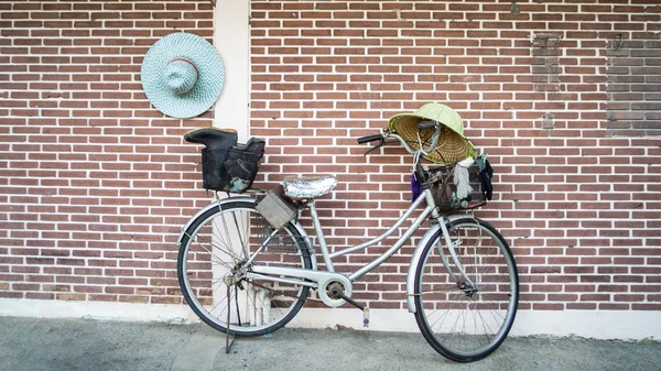 Old bicycle with a basket leaning against a wall — Stock Photo, Image