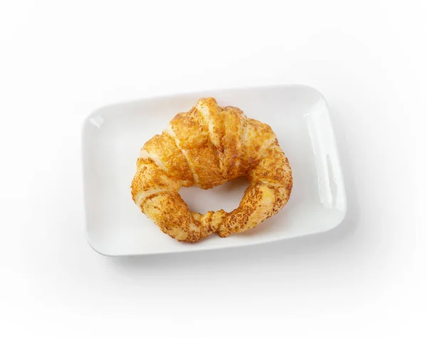 Croissant fresco aislado en un plato blanco sobre fondo blanco — Foto de Stock