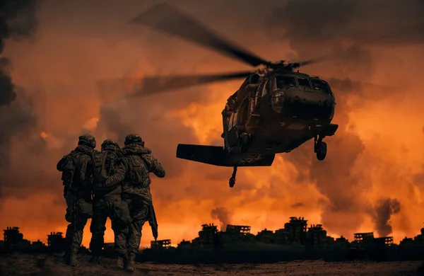 2 soldiers helping wounded soldier between dust in battle field to board the helicopter