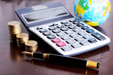 Dolma kalem ve hesap makinesi para yığını ve iş konsepti için toprak