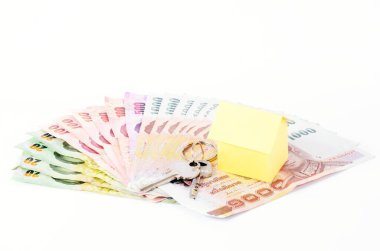Ev kredisi kavramının Tayland banknotları üzerine ev kağıdı ve anahtarlar