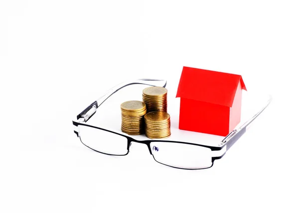 眼鏡とお金のコインスタックとローンのお金の概念のための赤い家の紙 — ストック写真