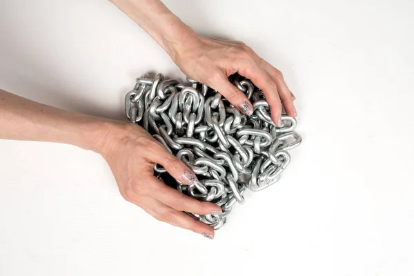 Gruesa cadena de metal en las manos de las mujeres sobre fondo blanco aislado —  Fotos de Stock