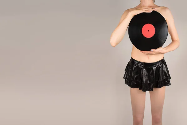 Sexig naken flicka i svart kort kjol täckt med vinylskivor — Stockfoto