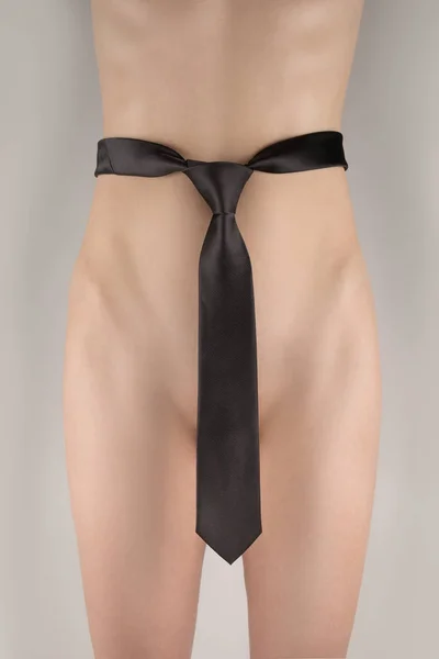 Naken flicka täckt man svart slips svarvning framifrån — Stockfoto