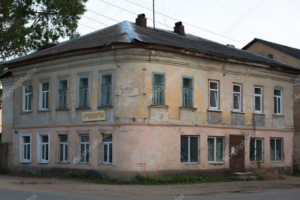 old stone tumbledown two-storey house in russian provincial town at sunset.concept of dying small russian towns