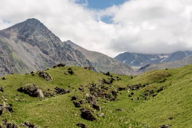 Derin vadisi olan dağ manzarası. Dağlar, yeşil geçit. Güzel tepeleri ve kayaları olan resim gibi bir manzara. Olağandışı rahatlamaya renkli bir bakış açısı. Kafkasya Dağı