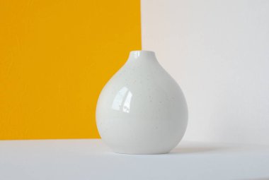 beyaz-sarı arka plan üzerinde beyaz yuvarlak vazo