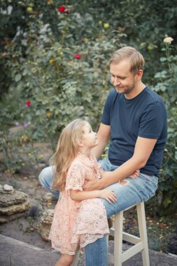Sevimli küçük kız ve yakışıklı genç babası söz ve birlikte yaz bahçede oynarken gülümseyen