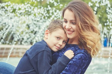 Genç güzel anne ve oğlu birlikte zevk. Mutlu bir aile. Olumlu insan duyguları, duygular, sevinç.