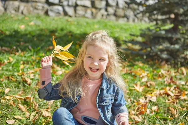 Szczęśliwa Dziewczynka Siedzi Trawie Jesienny Dzień Słoneczny — Zdjęcie stockowe