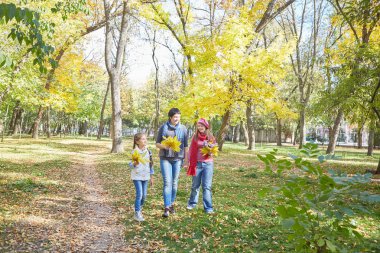 Mutlu bir aile. Sevgi dolu bir anne ve iki kızı sonbahar park. Down sendromlu bir özürü olan bir kız. Olumlu insan duyguları, duygular.