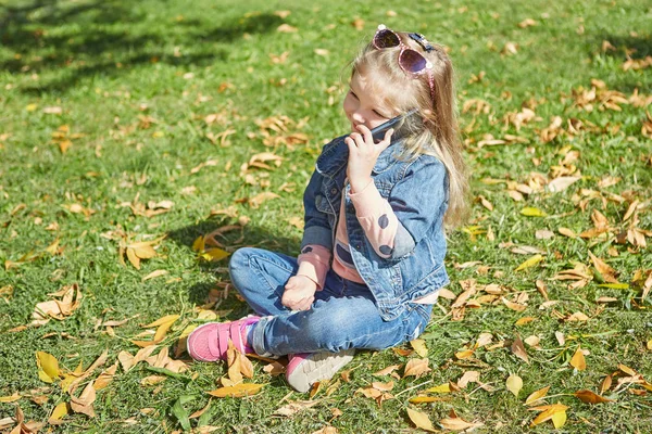 Маленька Дівчинка Мобільним Телефоном Вона Тримає Смартфон Сидячи Траві — стокове фото