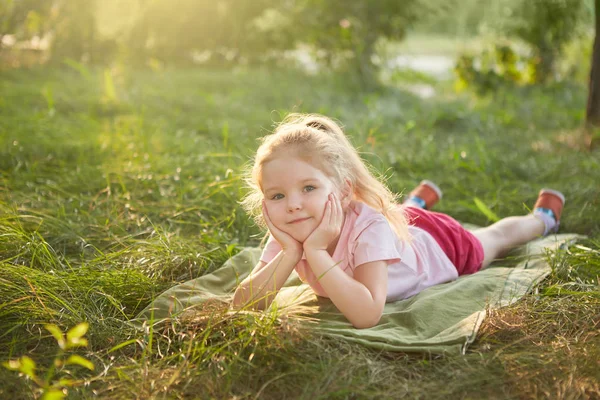 Mała dziewczynka leży na trawie — Zdjęcie stockowe