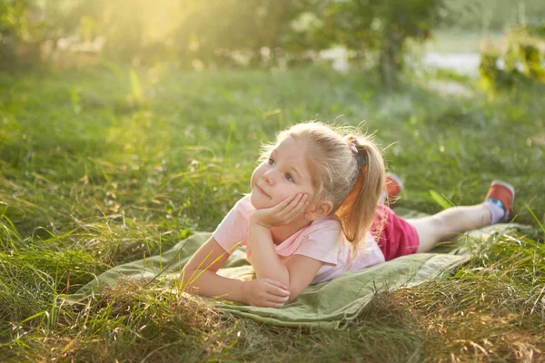 Niña está acostada en la hierba — Foto de Stock