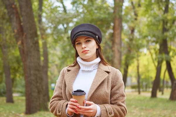 Beautiful woman in autumn park with coffee — Stock Photo, Image