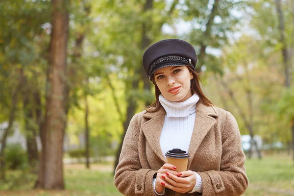 Schöne Frau im Herbstpark mit Kaffee — Stockfoto