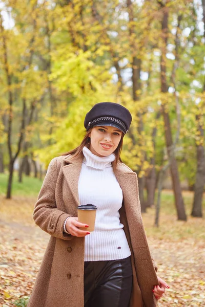 Belle femme dans le parc d'automne avec café — Photo