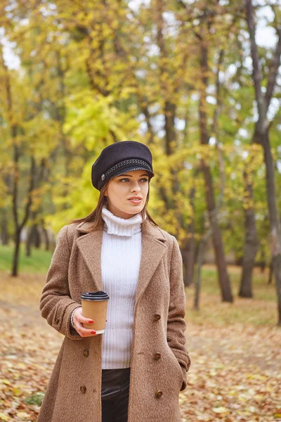 コーヒーと秋の公園で美しい女性 — ストック写真