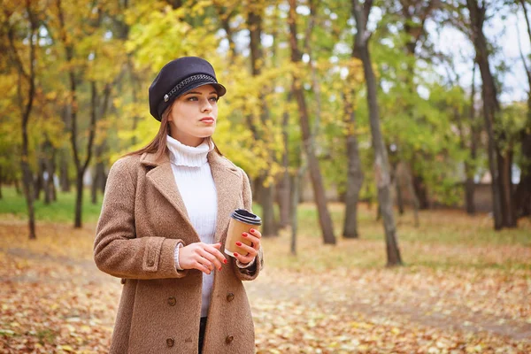 Belle femme dans le parc d'automne avec café — Photo