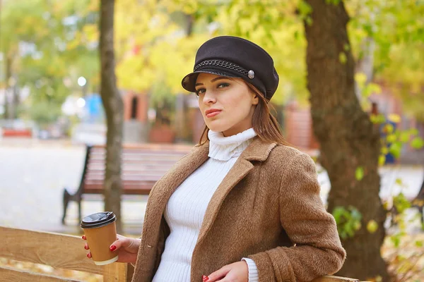 Krásná žena v podzimním parku s kávou — Stock fotografie