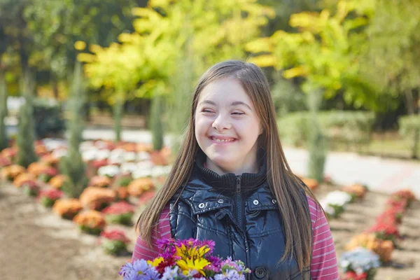 A Down-szindrómás lány őszi parkban. — Stock Fotó