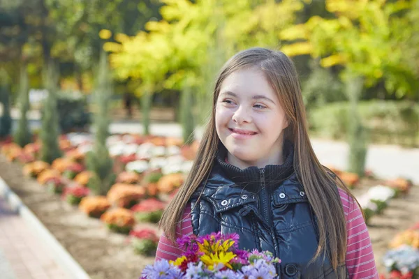 Chica con síndrome de Down en el parque de otoño . — Foto de Stock